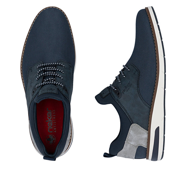 Pair of navy blue casual shoes with white soles on a white background