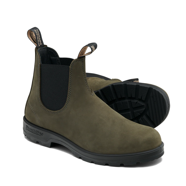 Pair of green Chelsea boots with black soles on a white background