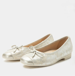 Pair of silver flat shoes with bow details on a white background