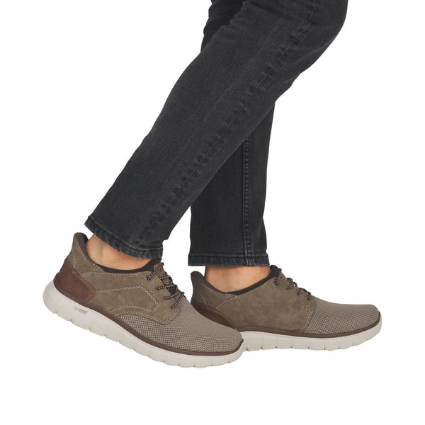 Brown casual shoes worn with black jeans on a white background
