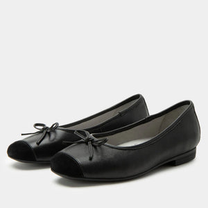 Pair of black leather shoes with a bow on a white background