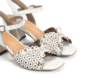 White high-heeled shoes with decorative elements on a white background