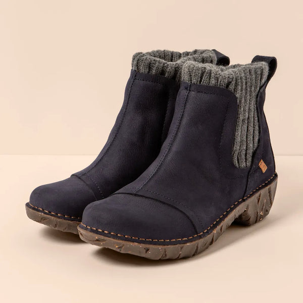 Pair of navy blue ankle boots with gray ribbed cuffs on a beige background